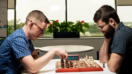 Two people playing chess at the office