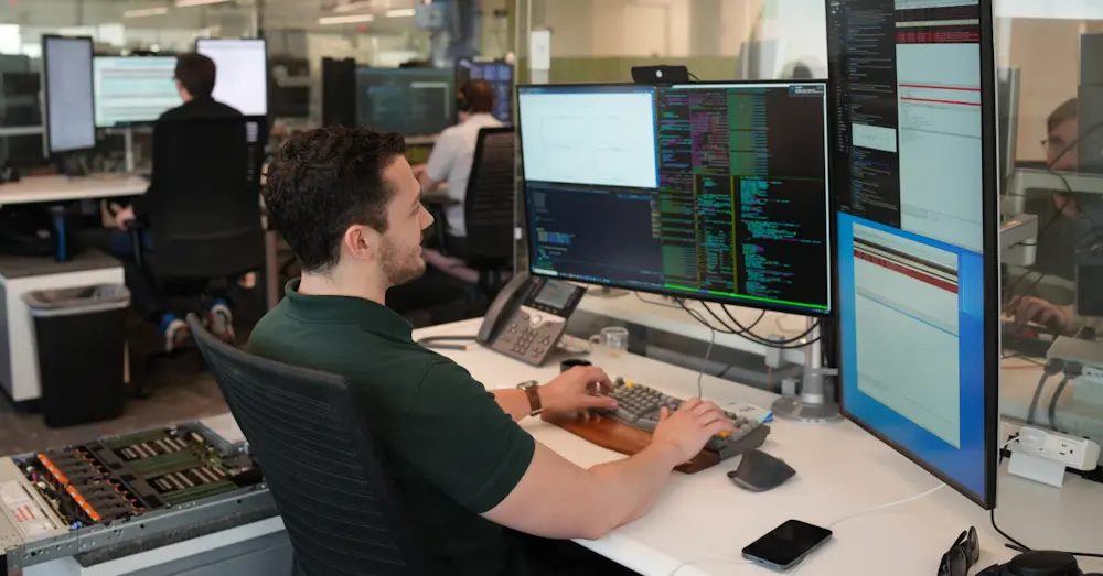 man sitting at trading desk with multiple monitors 