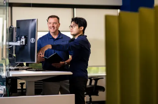 Two people standing at a trading desk