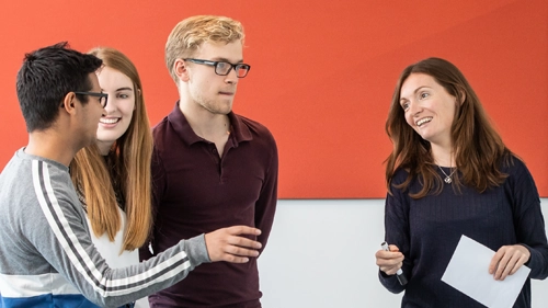 Four people discussing at a whiteboard