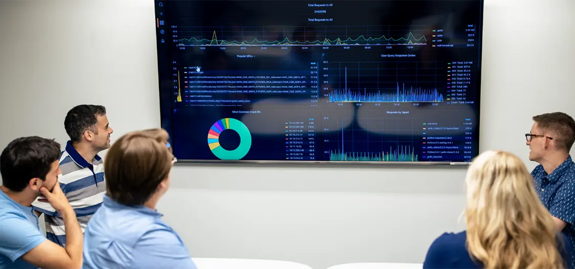 A team analyzing data on a TV in the center