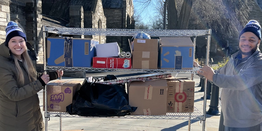 Two people moving packages together