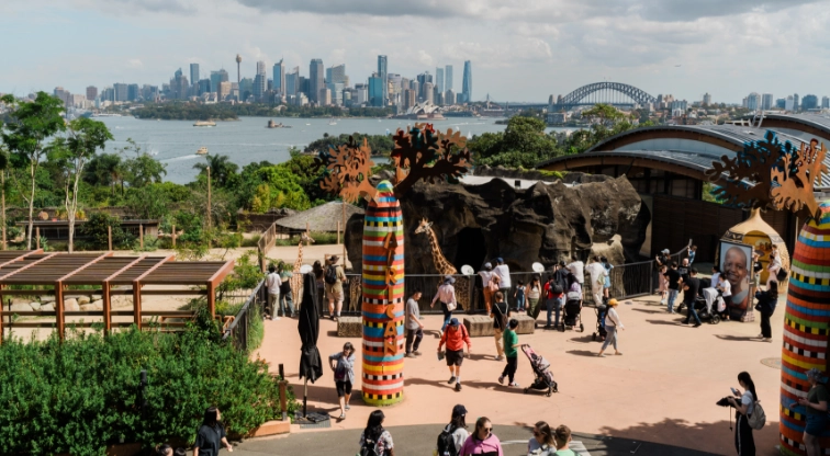 People at the zoo from above, with the city skyline in the background